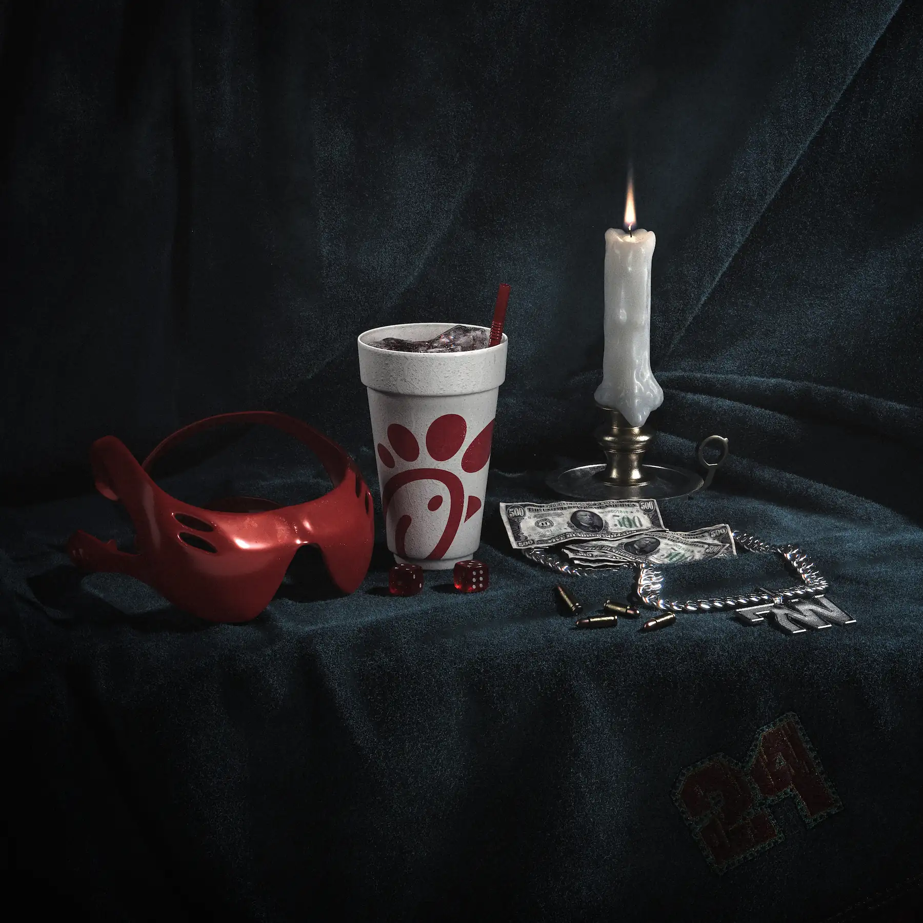 3D still life on dark velvet: red goggles, a styrofoam cup, a candle, dollar bills and dice
